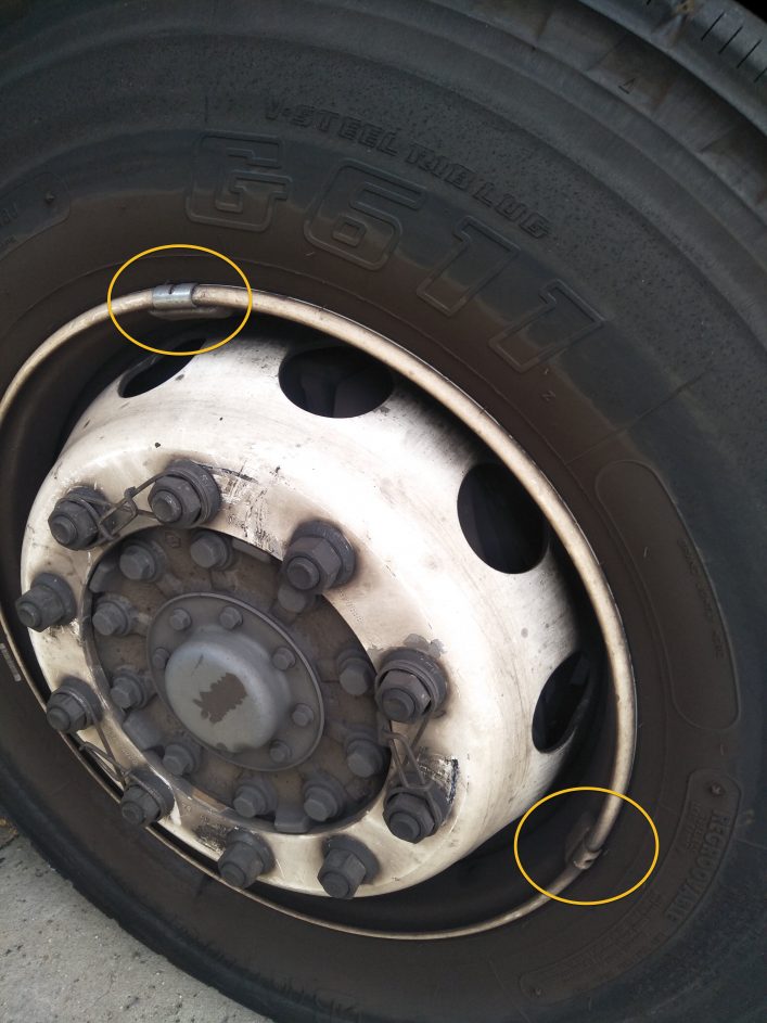 Photo showing a new counter-weight added to a truck tyre - and the old one has not been removed.